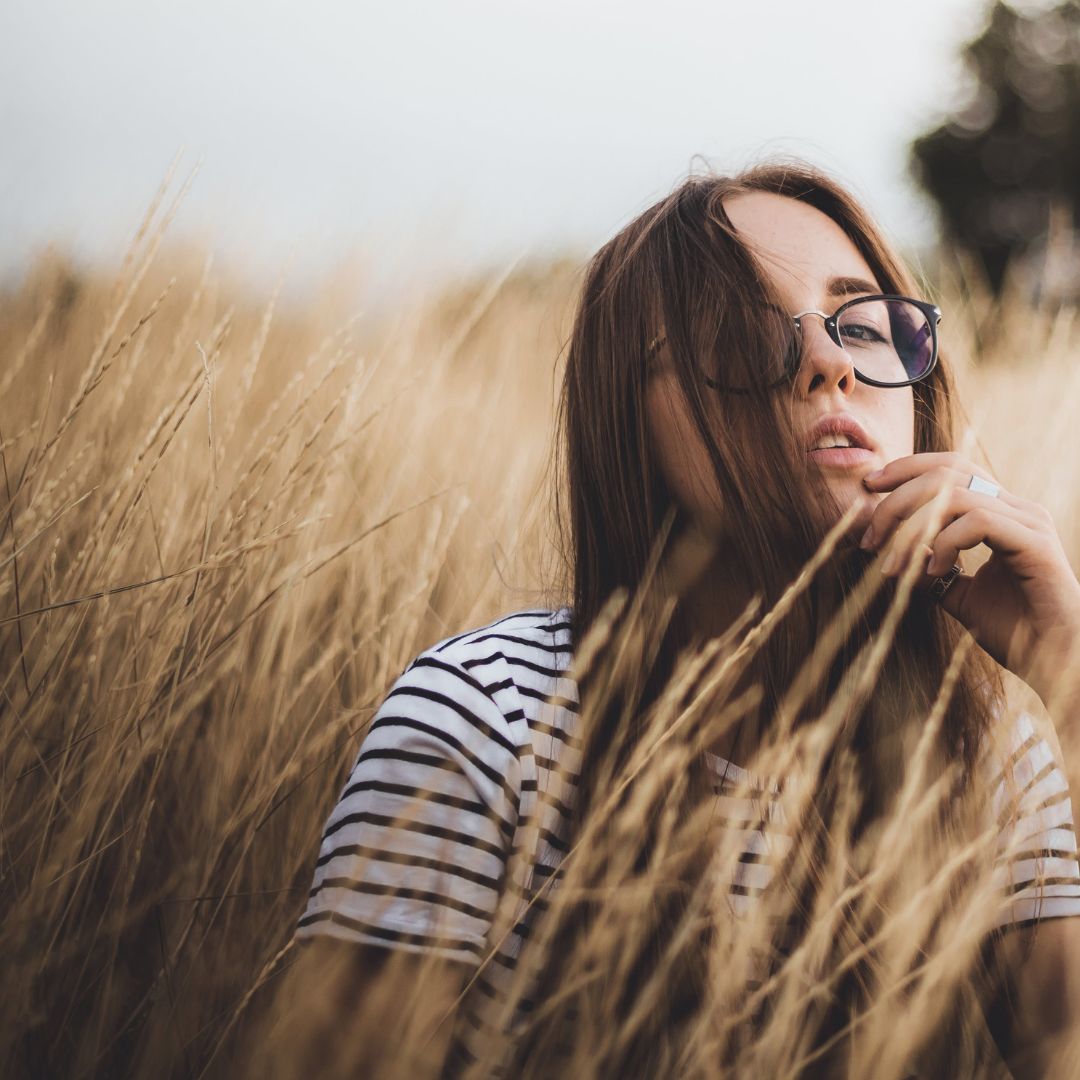 Noia pensativa en un camp de blat